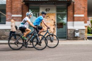 Ein P&auml;rchen f&auml;hrt auf E-Bikes durch die Stadt.
