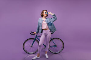 slim blithesome woman posing with bicycle indoor full length shot of curly female model in purple pants 1 300x200 - Schl&uuml;ssel vom Fahrradschloss oder E-Bike verloren - Was tun?