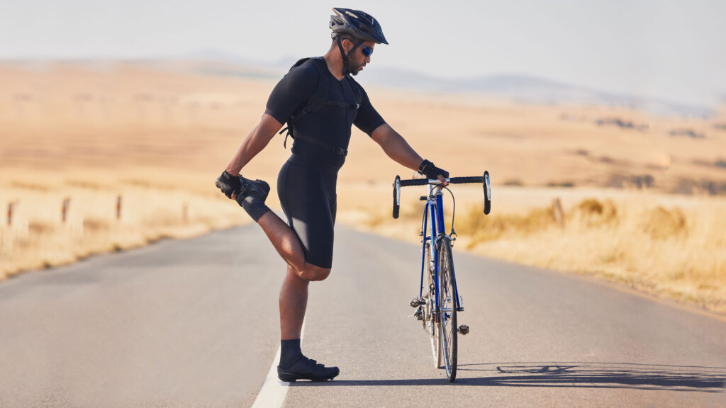 Radfahrer Training - Fahrradfahrer dehnt sich an seinem Fahrrad