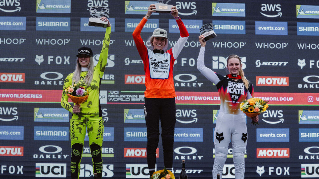 Rosa Zierl strahlt auf dem Podium in Leogang 2025 und hebt ihre Troph&auml;e nach dem Downhill-Sieg in der Juniorinnen-Kategorie, neben ihr die weiteren Gewinnerinnen