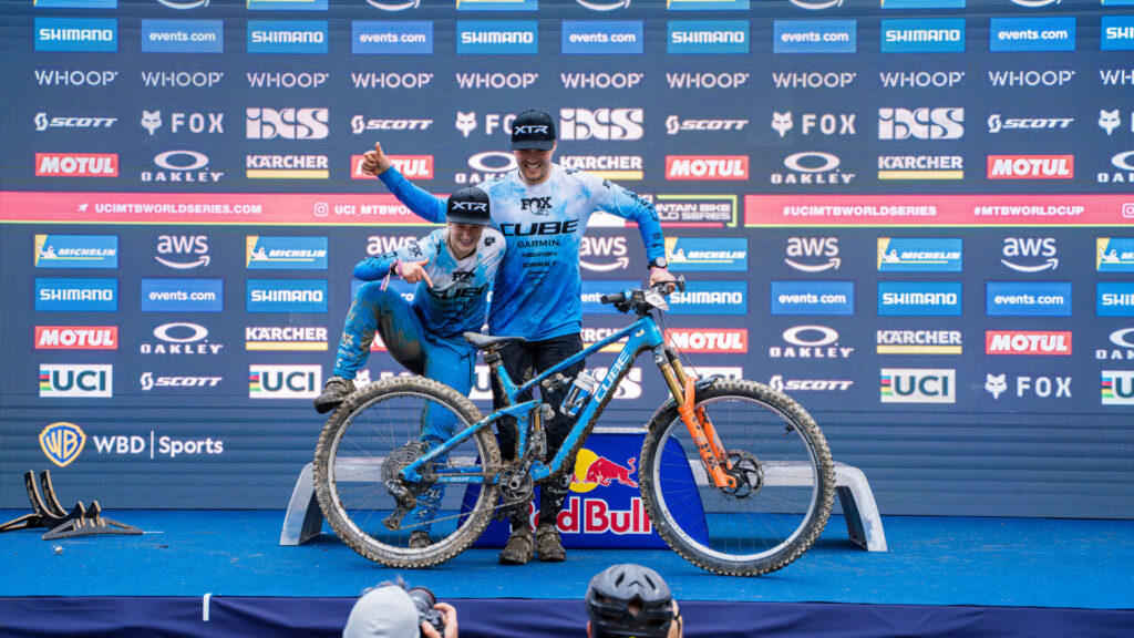 Simona Kuchynkova und Zakarias Johansen posieren mit einem CUBE Stereo ONE77 vor dem Podium in Leogang 2025 f&uuml;r Fotografen nach ihren Erfolgen im Enduro World Cup