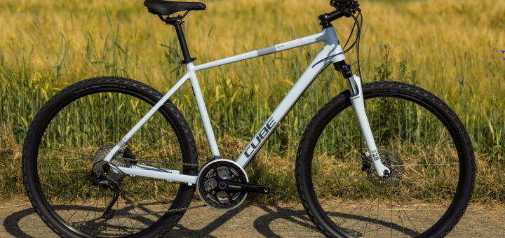 Cube Nature Crossbike auf Feldweg – sportliches Fahrrad vor grün-gelbem Wiesenhintergrund