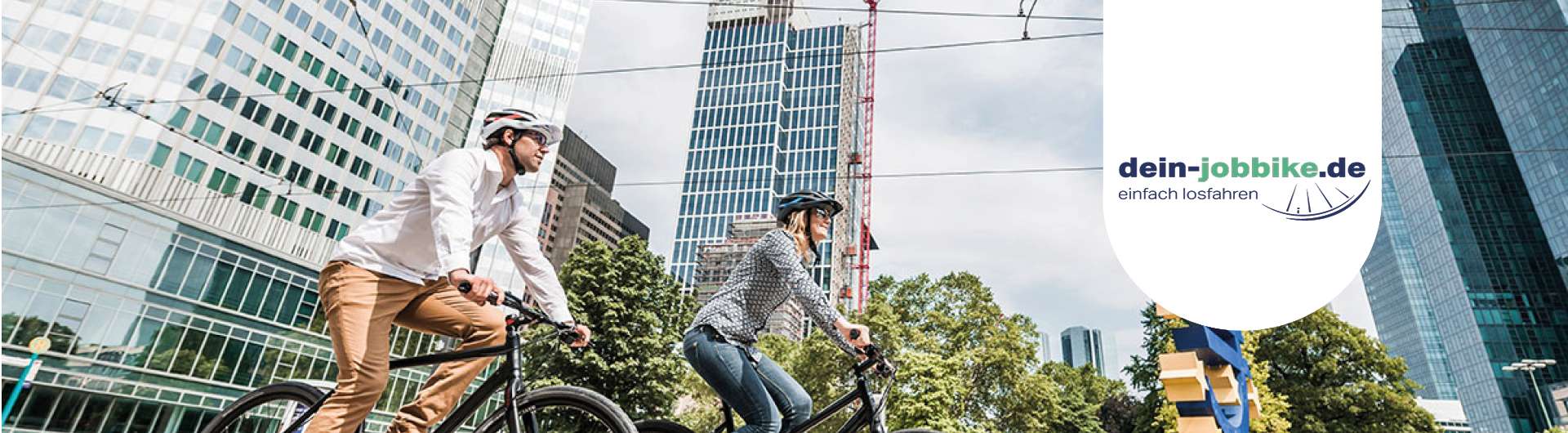 Ein Mann und eine Frau fahren mit ihren Fahrrädern durch die Stadt. Neben ihnen ist das dein-jobbike.de-Logo zu sehen.